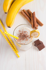 Fresh Made Chocolate Banana Smoothie on a wooden table. Selective focus. Milkshake with almonds. Protein diet. Healthy food and drink concept.