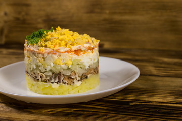 Traditional russian salad Mimosa on wooden table