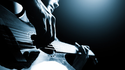 male professional musician playing acoustic guitar on stage, music background