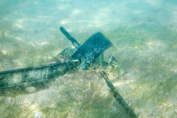 Lowered ship anchor on the sandy bottom of the sea