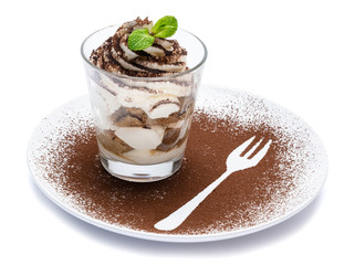 Classic tiramisu dessert in a glass on plate with fork silhouette isolated on a white with clipping path