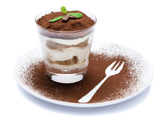 Classic tiramisu dessert in a glass on plate with fork silhouette isolated on a white with clipping path