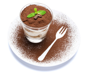 Classic tiramisu dessert in a glass on plate with fork silhouette isolated on a white with clipping path