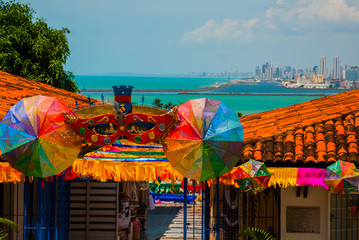 Olinda, Brazil: A view of the Handicraft's Market in Olinda's historic center, cityscape of Recife in the background - obrazy, fototapety, plakaty