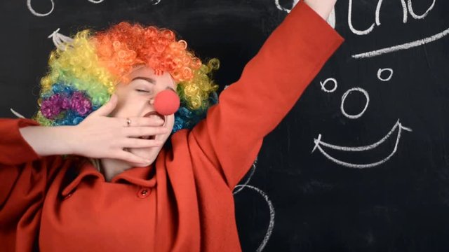 the girl in the clown costume grimaces