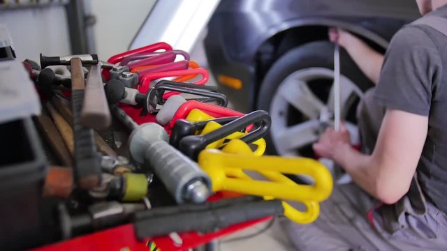 Paintless Dent Repair. The master aligns the dent hook on the car without painting in the auto repair shop. Technology, car repair shop, tools, Amazon, advertising, equipment, easy to use.