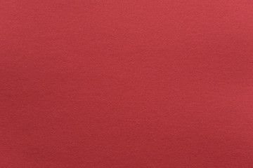 Abstract red glossy paper texture background or backdrop. Empty wrapping paper or shiny paperboard for decorative design element. Grainy surface for christmas holiday or Chinese new year concept