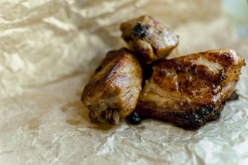 Pieces of roasted barbecue on wrapping paper. Close-up.