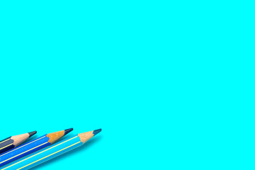 colored blue pencils on a bright blue background
