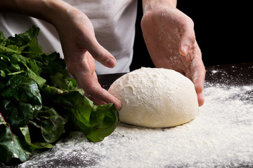 Female hands making fresh dough on wooden table. Close up