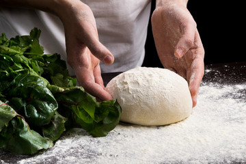 Female hands making fresh dough on wooden table. Close up