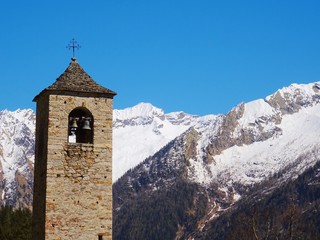 View of a church in the Italian Alps on a sunny day in the village of Macugnaga, Italy - April 2019