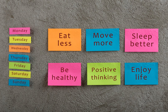 Health and motivation concept - Many colorful sticky note with words eat less, move more, sleep better, be healthy, positive thinking, enjoy life and days of week
