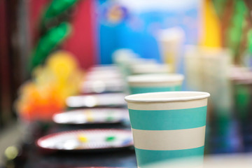 Paper cups on table and decoration prepared for kids birthday party. Blue theme baby boy.