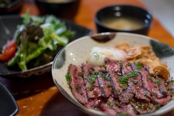 Steak Don, a Japanese dish consisting of a bowl of rice topped with rare beef with egg