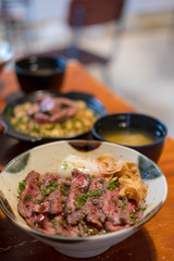 Steak Don, a Japanese dish consisting of a bowl of rice topped with rare beef with egg
