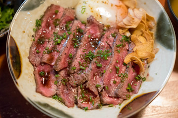 Steak Don, a Japanese dish consisting of a bowl of rice topped with rare beef with egg