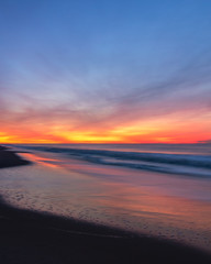 Fototapeta na wymiar Soft pastel colors in the pre dawn sky over a peaceful coastal scene. Beach located on Long Island New York. 