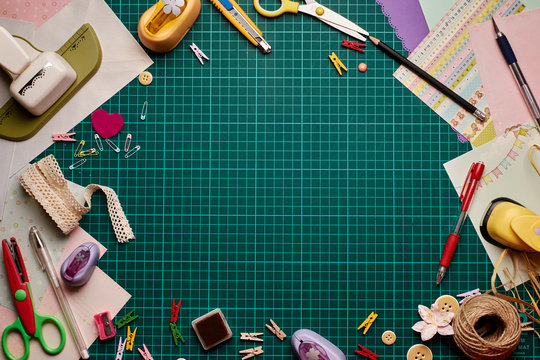 Tools for scrapbooking on the cutting mat. Copy space in the middle.