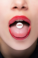 White pill with an inscription AIDS in the language of the girl close-up Macro.