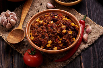Mexican quinoa warm salad, chili, vegetarian food on dark wood background.