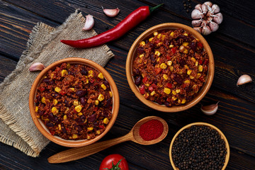 Mexican quinoa warm salad, chili, vegetarian food on dark wood background. Top View.