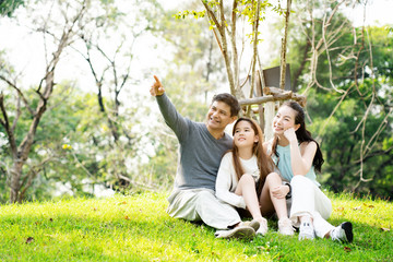 Concept Father and Mother's Day. Asian family is Sitting and chatting the park for Summer which is ideal for long weekend vacations. Taking care of family makes children feel the love of parenting.