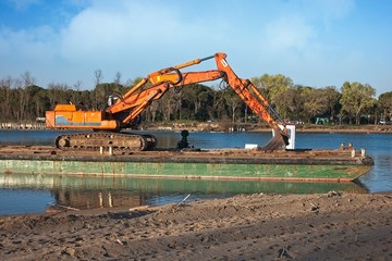 Excavator for channel dredge on a barge.