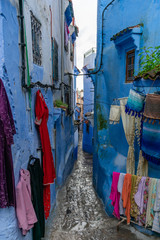 Tight and Narrow Blue Street in the Medina of Chefchaouen Morocco with Clothing for Sale