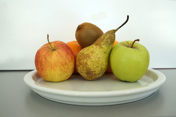 Fruit served on the tray and photographed on white plate