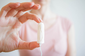 Girl holding tampon during the monthly cycle. Young woman hands holding menstruation cotton tampon 