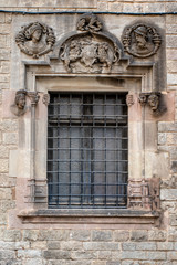 Windows in a facade of an old Medieval building in the Gothic Quarter (Barrio Gotico) in Barcelona, Spain