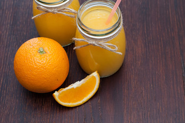 Orange and juice in two cans. Rustic style. Side view and from the top. Copy space.