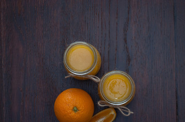 Orange and juice in two jars, rustic style top view, copy space, flat lay