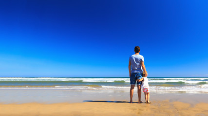 Father and daughter have fun on the seashore.