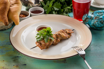 Grilled chicken kebab on bamboo skewer with ketchup on blue wooden table