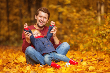 Father and daughter hug and laugh in the autumn park.