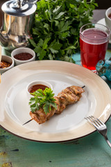 Grilled chicken kebab on bamboo skewer with ketchup on blue wooden table