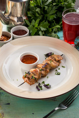Grilled chicken kebab on bamboo skewer with ketchup on blue wooden table