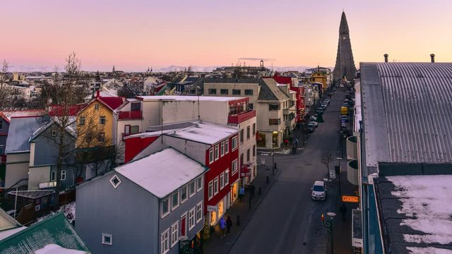 Time lapse of Reykjavik city centrum evening life -moving cars and people on the road. The central street leads to the most famous church - aerial view from above