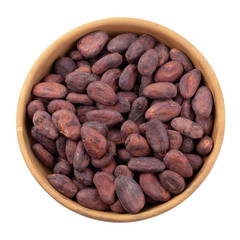 Cocoa fruit in a wooden bowl, raw cacao beans isolated on a white background