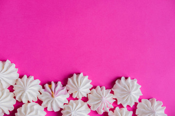 Frame for text with color meringues. Background for a banner with sweets. Multicolored meringues on a white wooden background. Basis for confectionery banner, cafe, sweet shop. Meringue banner