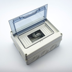 Plastic gray plastic electrical installation junction box on a white background. Electric switchboard on the white wall of a factory.
