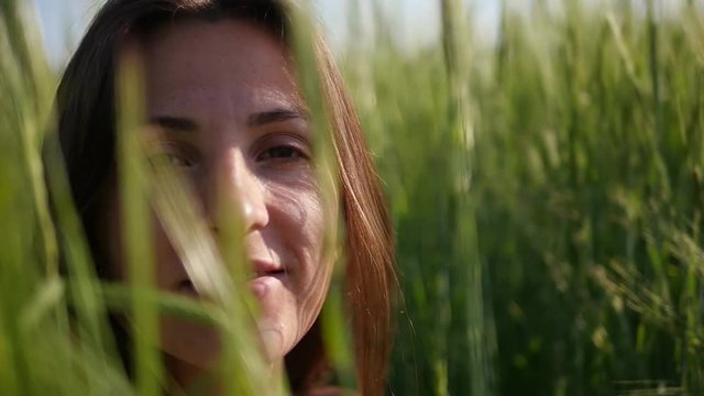 Beautiful girl in the grass in the meadow. Enjoy the nature. Close slow motion