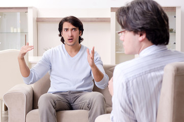 Young male patient discussing with psychologist personal problem