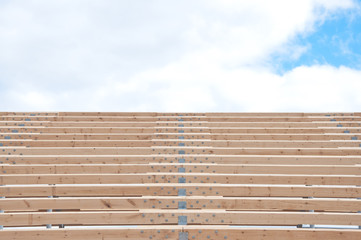 Wooden beams and metal frame of the new building. The use of two materials in construction. Wood and metal at a construction site.