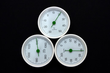 Barometer, thermometer, hygrometer isolated on black background.