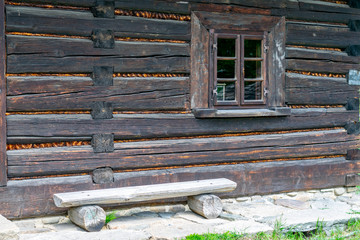 A small window in the wall of an old wooden house
