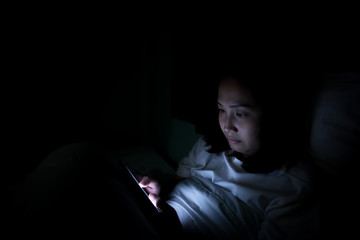 Fototapeta na wymiar Asian woman playing game on smartphone in the bed at night,Thailand people,Addict social media