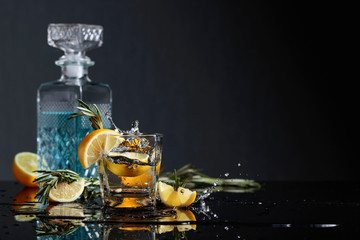 Cocktail gin-tonic with lemon slices and twigs of rosemary.